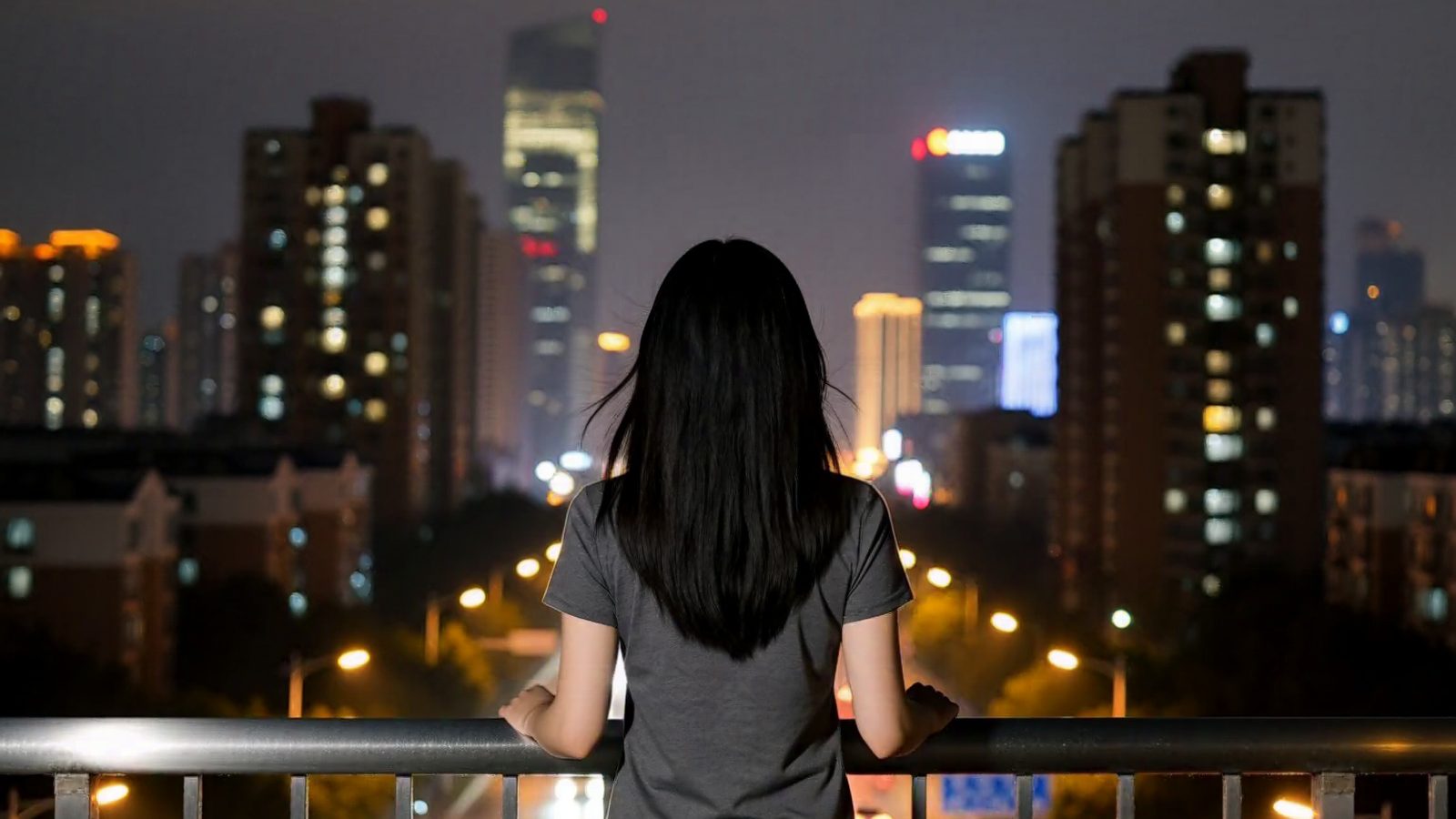 YURA seen from behind at a rooftop railing, looking out over a city at night.